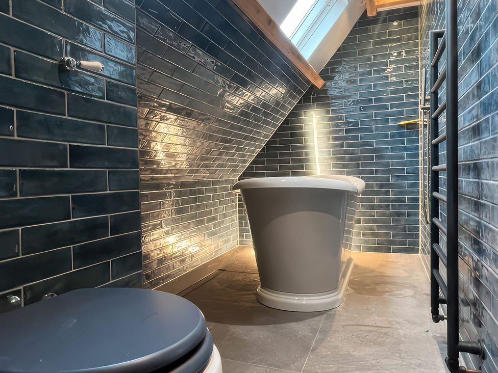 A bathroom with a bathtub and a toilet at Your Country House in Reading