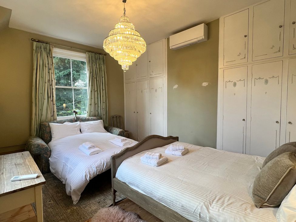 A bedroom with two beds and a chandelier at Your Country House in Reading