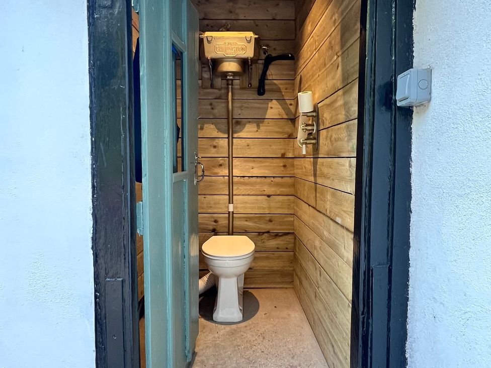 A bathroom with a toilet and wooden walls at Your Country House in Reading