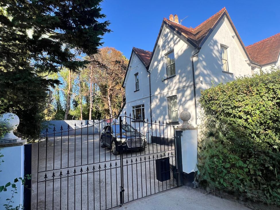 An outdoor view of a house with a gate and car at Your Country House in Reading