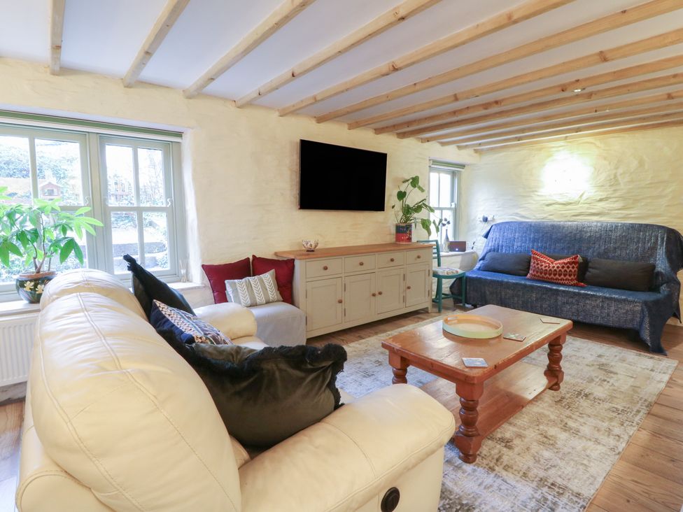 A living room with a sofa and coffee table at Penally Mews in St Dogmaels