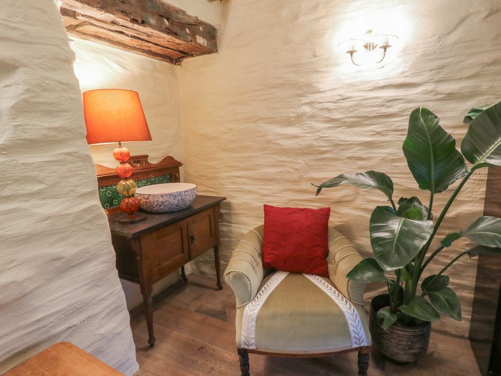 A sitting room with a chair and lamp at Penally Mews St Dogmaels