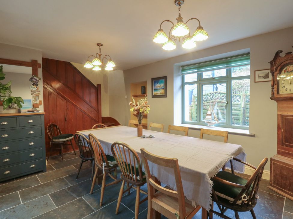A dining room with a large table and chairs at Penally Mews in St Dogmaels