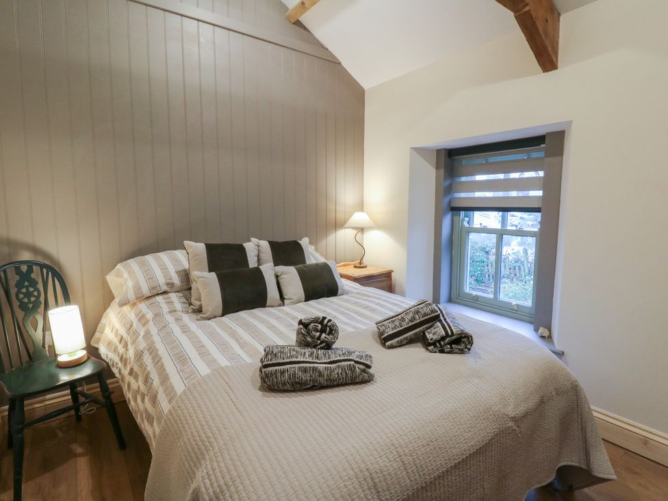 A bedroom with a bed and lamp at Penally Mews St Dogmaels