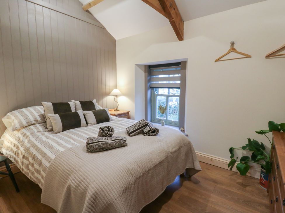 A bedroom with a bed and a window at Penally Mews St Dogmaels