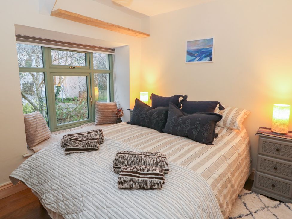 A bedroom with a bed and window at Penally Mews in St Dogmaels