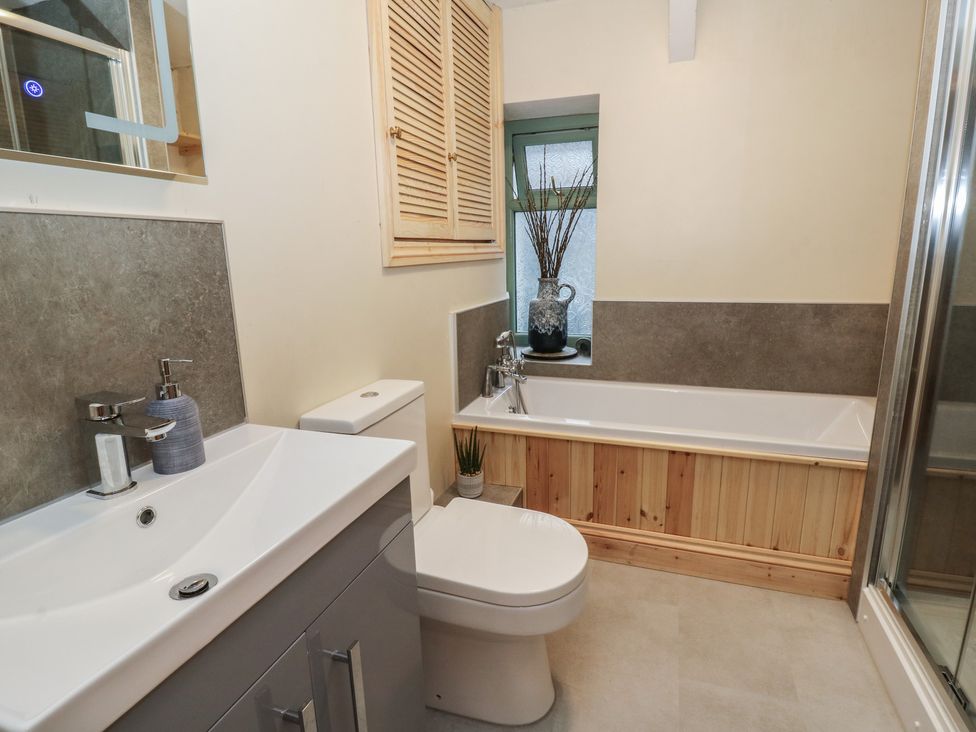 A bathroom with a bath tub and sink at Penally Mews St Dogmaels