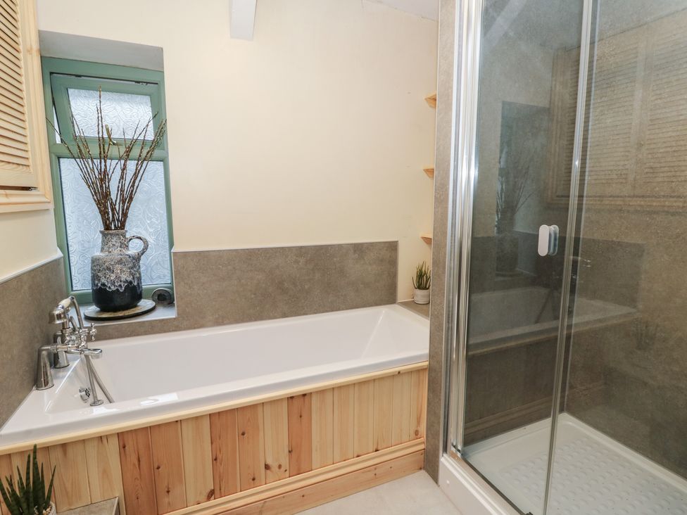 A bathroom with a bathtub and shower at Penally Mews St Dogmaels