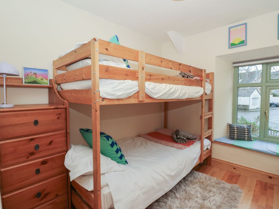 A bedroom with a bunk bed and a dresser at Penally Mews in St Dogmaels