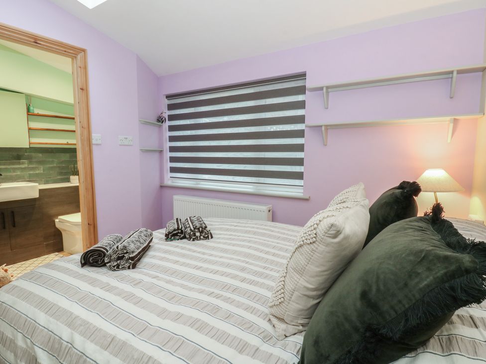 A bedroom with a bed and attached bathroom at Penally Mews St Dogmaels