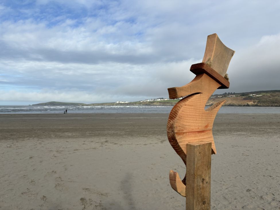 A wooden fish sculpture at the beach near the ocean at Penally Mews in St Dogmaels