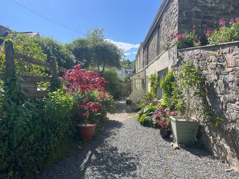 An outdoor area with a gravel path and flower pots at Penally Mews in St Dogmaels
