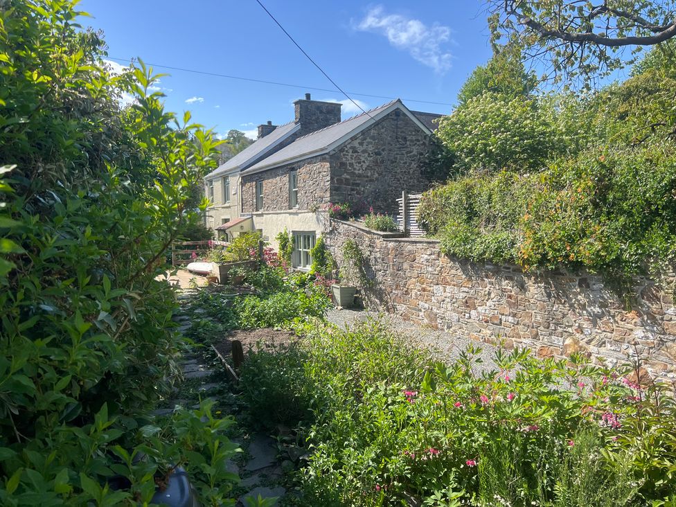 A house and garden with flowers at Penally Mews in St Dogmaels