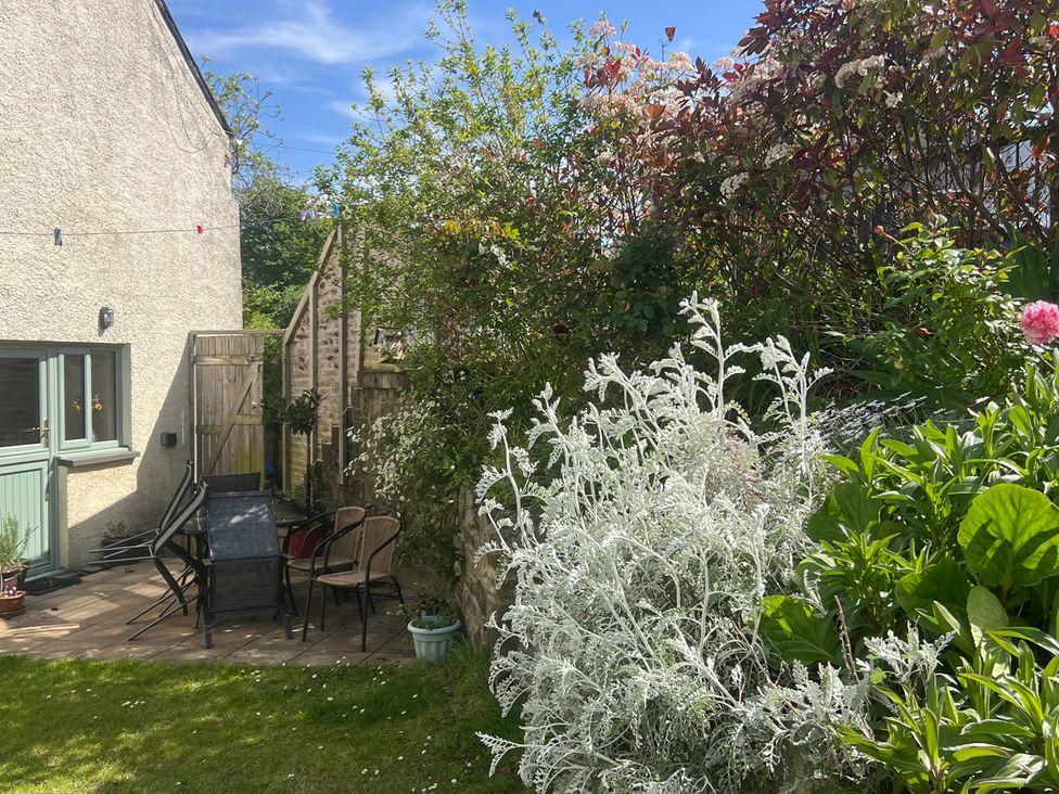 A garden with chairs and a table at Penally Mews St Dogmaels