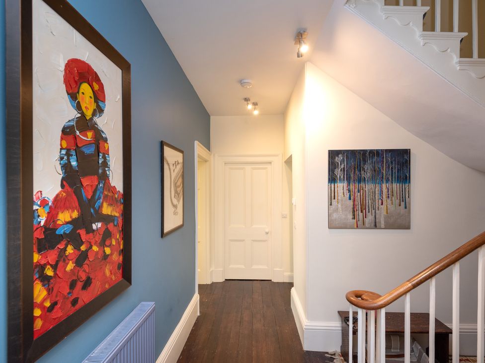 A hallway with paintings on walls at The Old Vicarage in St Issey