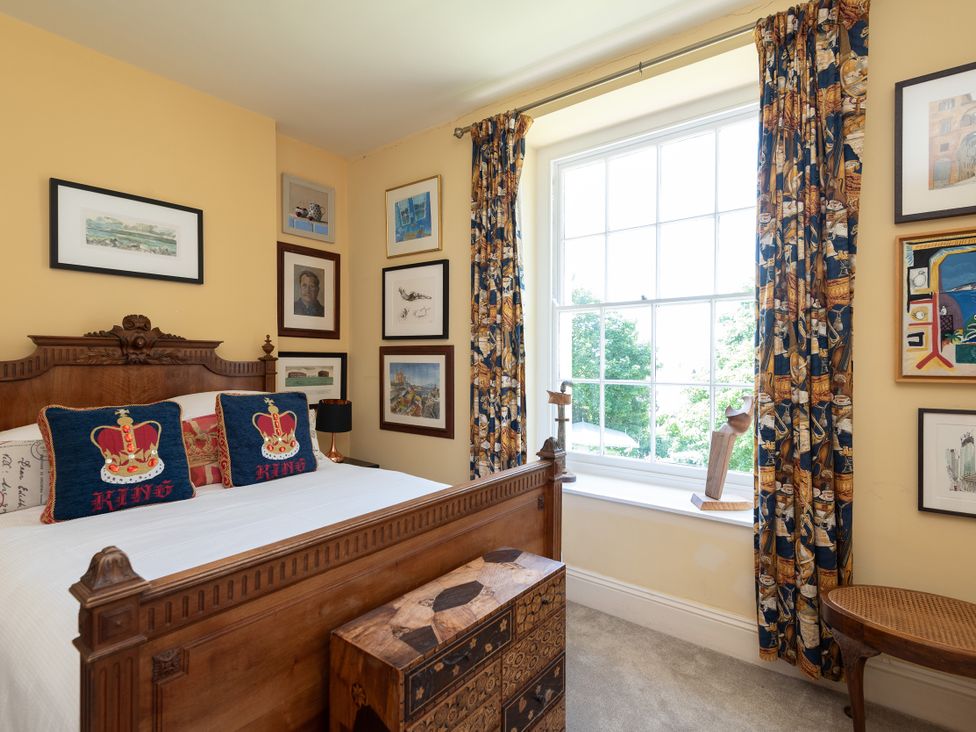 A bedroom with a bed and artwork on the walls at The Old Vicarage in St Issey