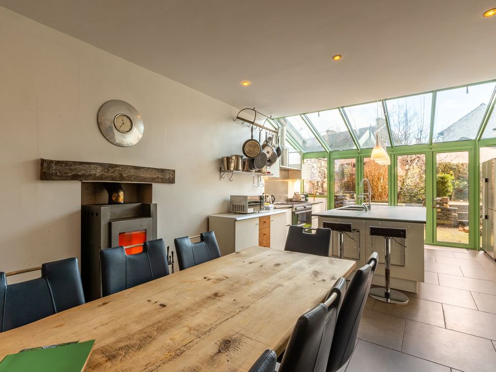 A kitchen with a long wooden table and modern appliances at The Boundary in Windermere
