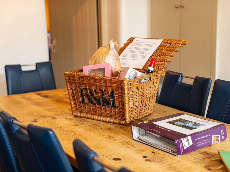 A dining room with a basket and a binder on the table at The Boundary in Windermere