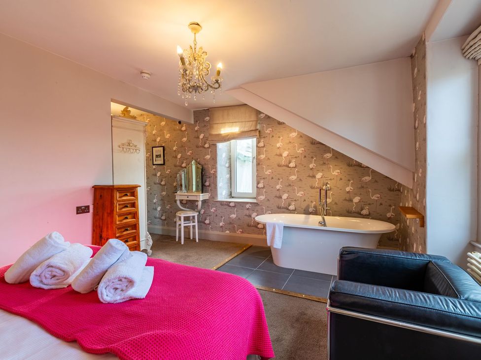 A bedroom with a bathtub and dressing table at The Boundary in Windermere