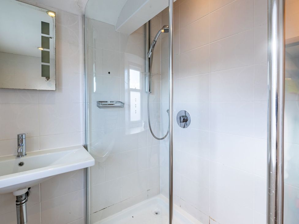 A bathroom with a shower, sink, and mirror at The Boundary in Windermere