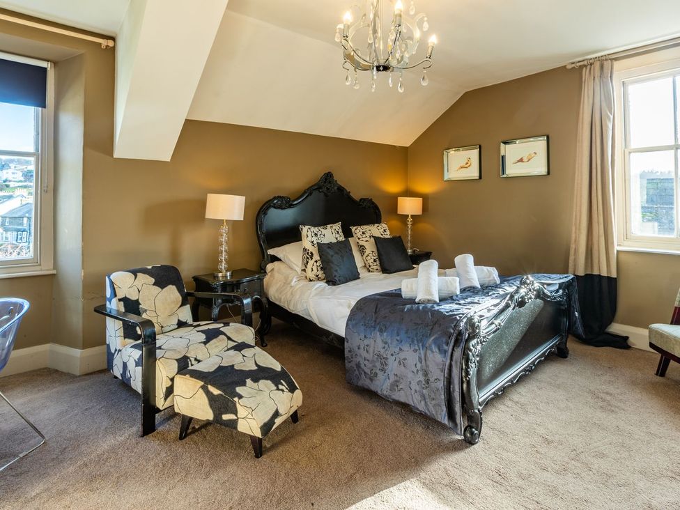 A bedroom with a bed and armchair at The Boundary in Windermere