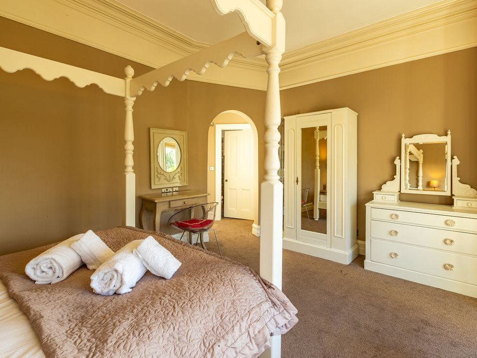 A bedroom with a four-poster bed and white furniture at The Boundary in Windermere