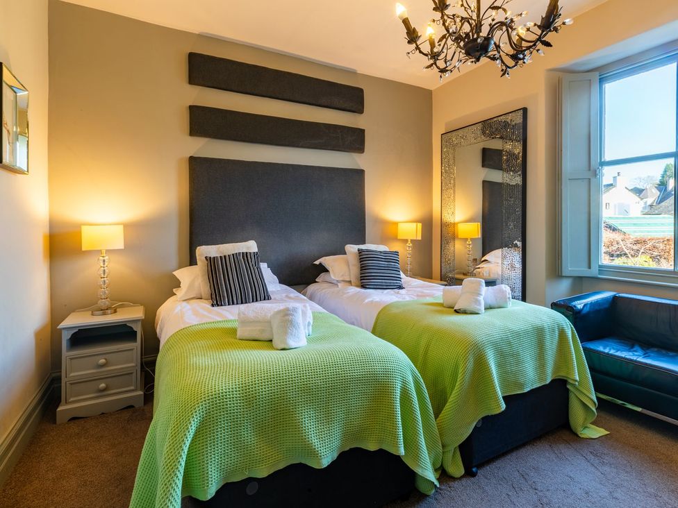 A bedroom with two beds and a mirror at The Boundary in Windermere