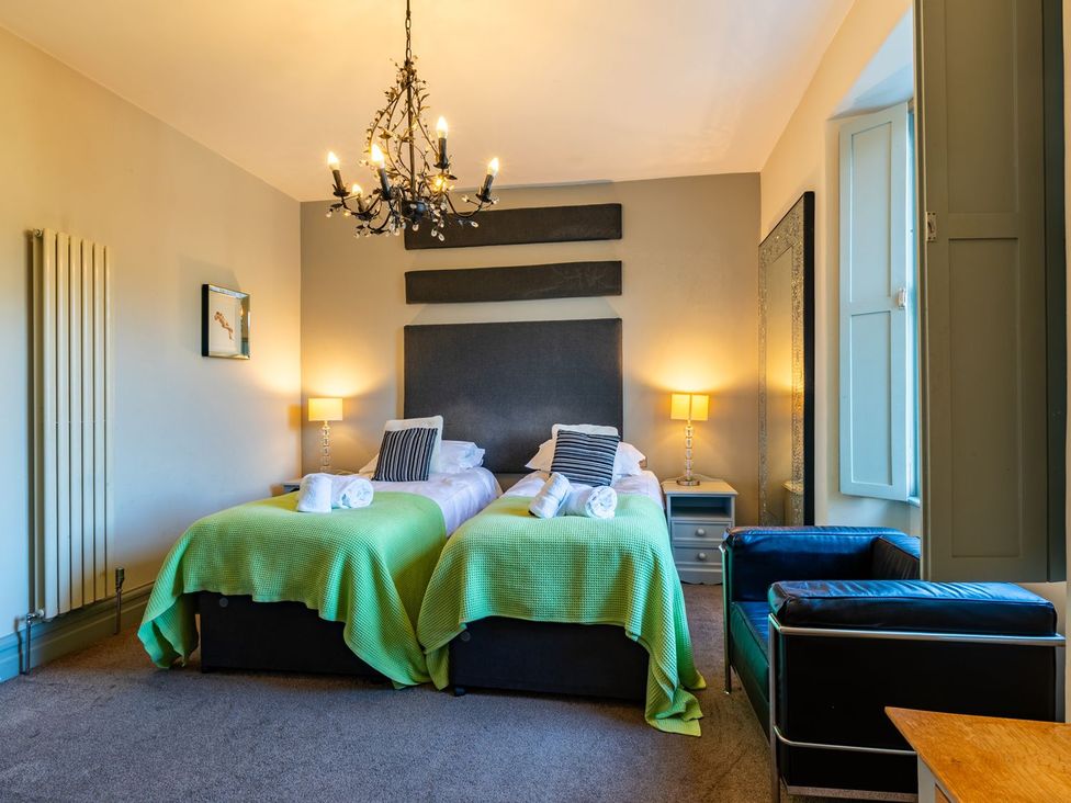 A bedroom with two beds and a chandelier at The Boundary in Windermere