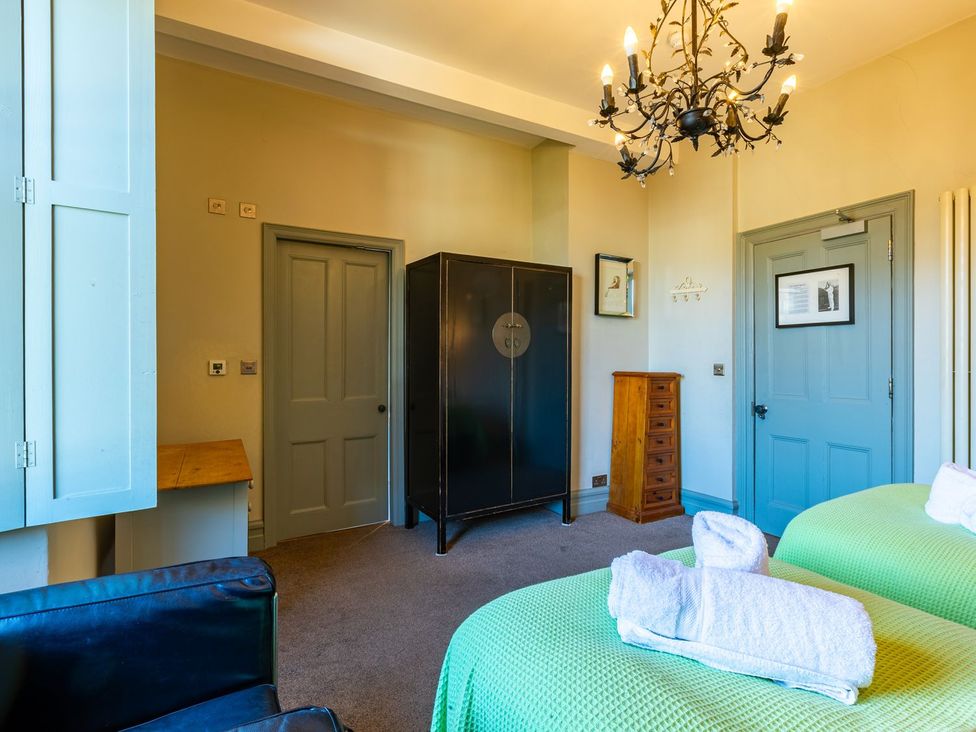 A bedroom with two beds and a wardrobe at The Boundary in Windermere