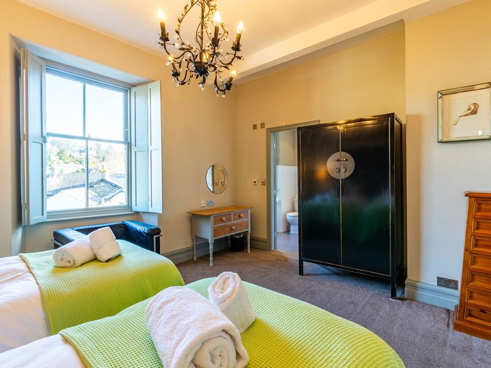 A bedroom with beds and a wardrobe at The Boundary in Windermere