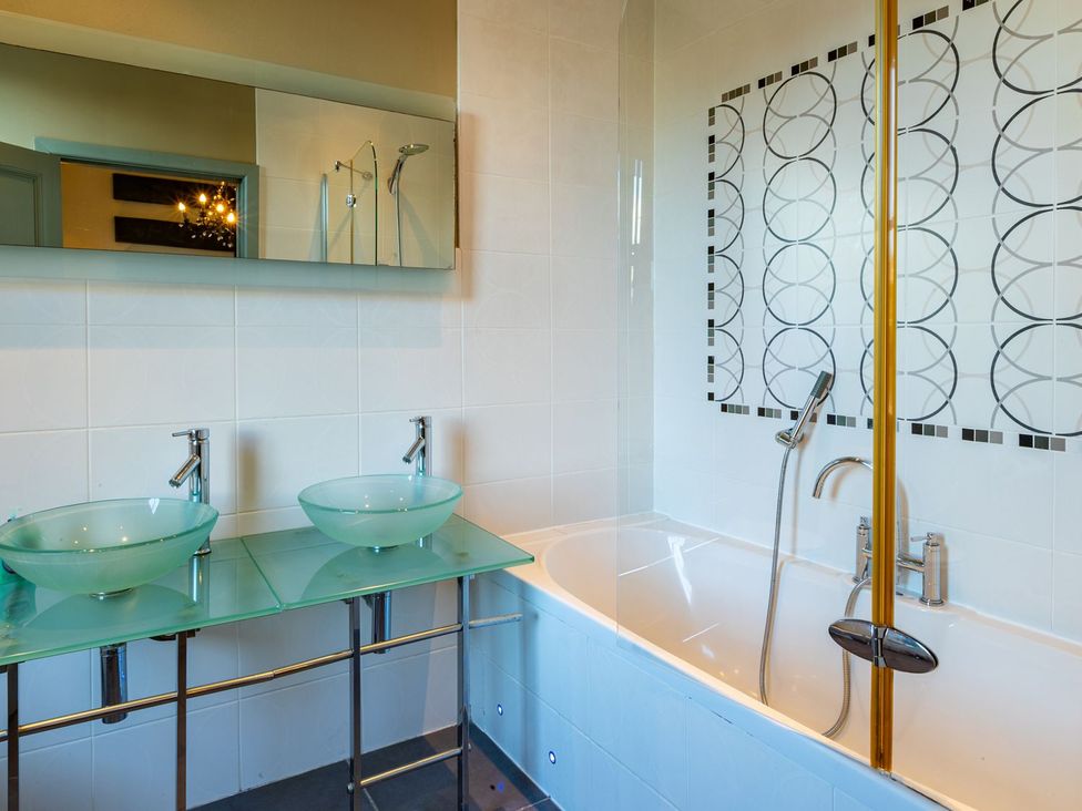 A bathroom with a sink, mirror, bathtub and shower at The Boundary in Windermere