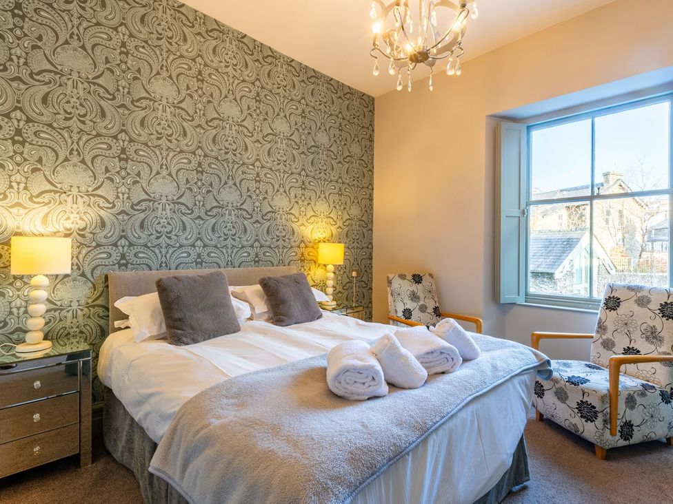 A bedroom with a double bed and two chairs at The Boundary in Windermere