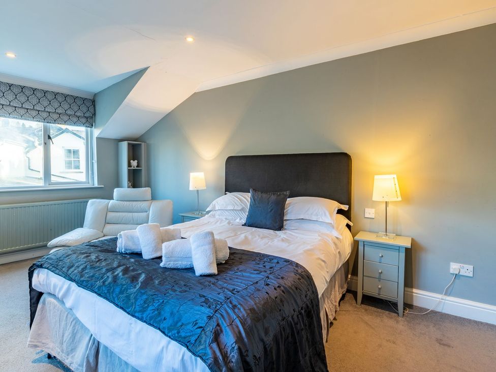 A bedroom with a bed and armchair at The Boundary in Windermere