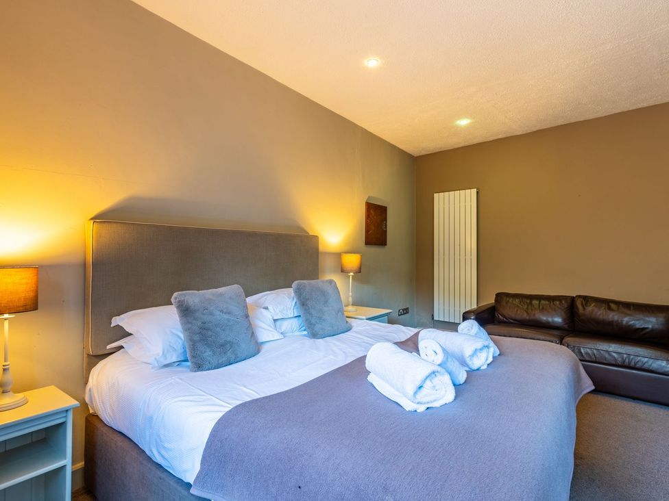 A bedroom with a bed and sofa at The Boundary in Windermere