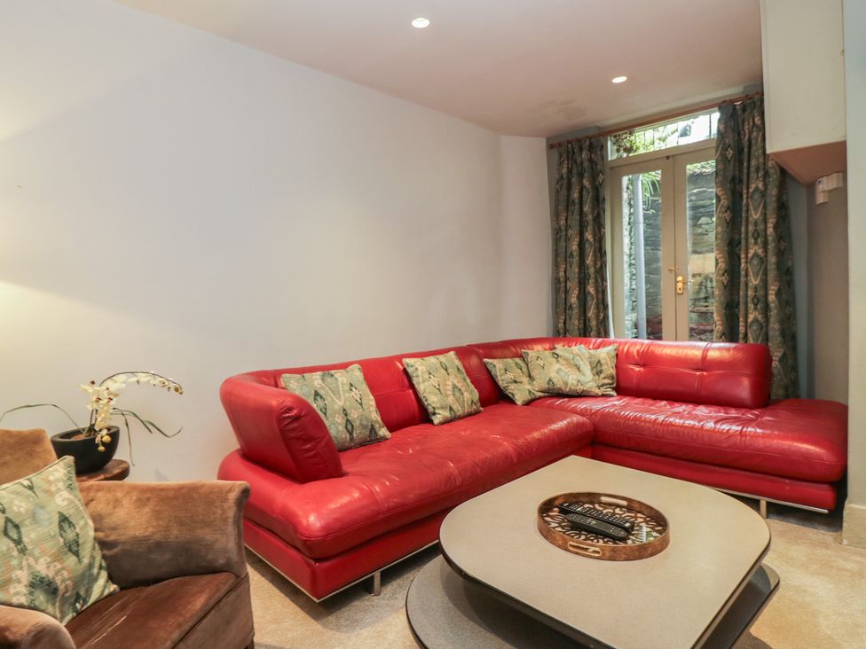 A living room with a red sofa and a coffee table at The Boundary in Windermere