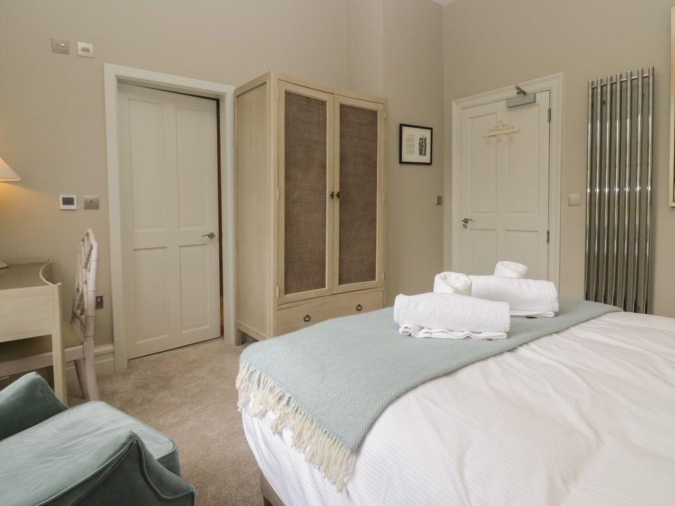 A bedroom with a bed, wardrobe, desk and chair at The Boundary in Windermere