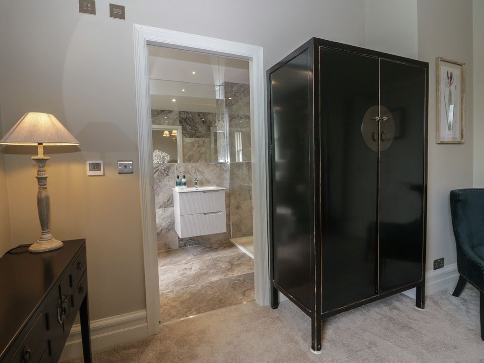 A bathroom with an open closet and a lamp at The Boundary in Windermere