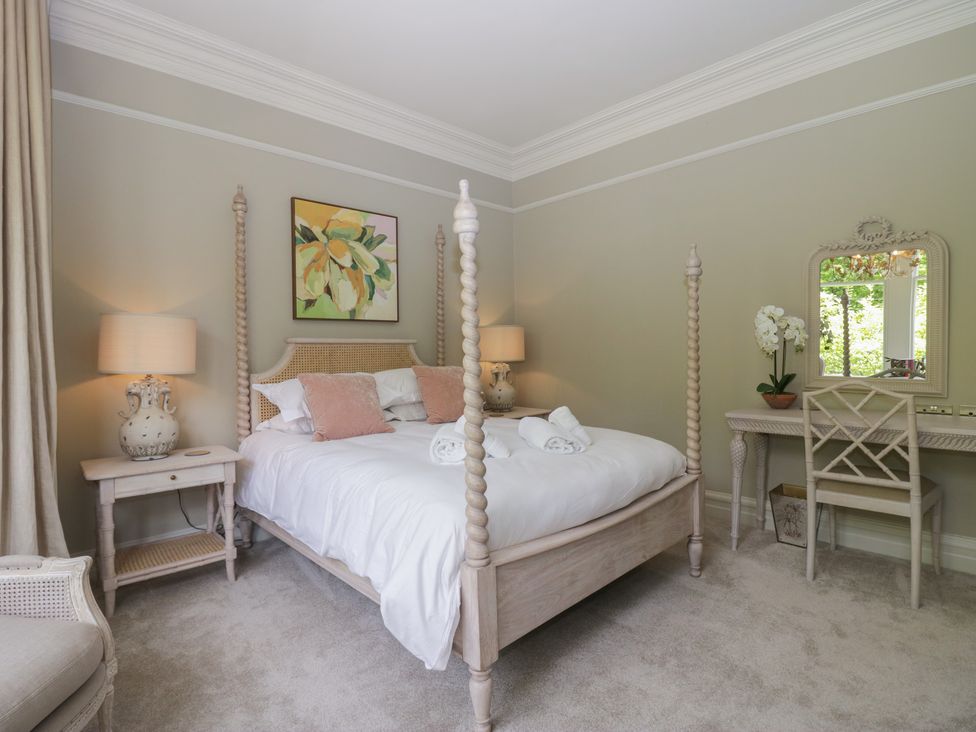 A bedroom with a bed, nightstand, and mirror at The Boundary in Windermere