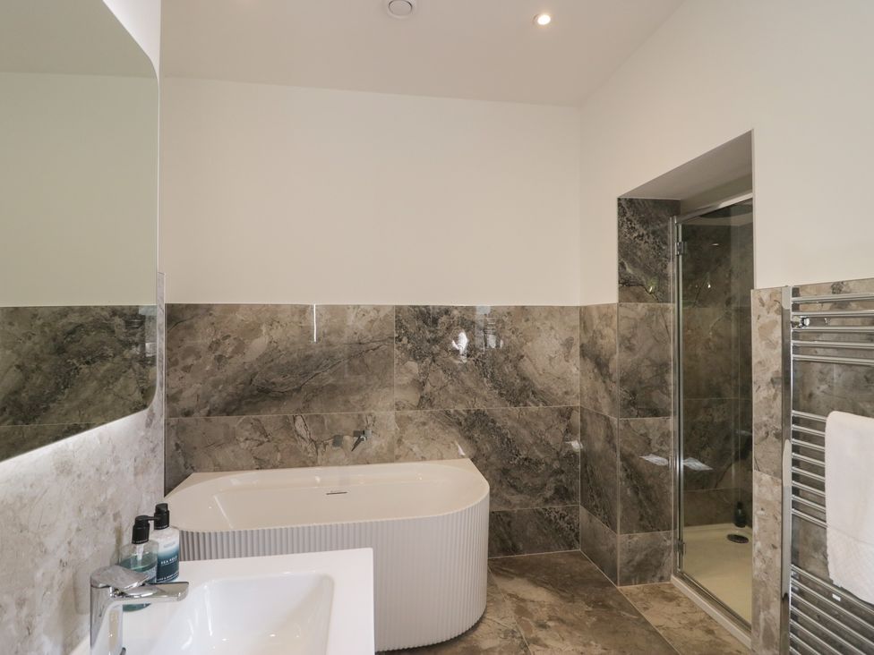 A bathroom with a shower, bathtub, and sink at The Boundary in Windermere