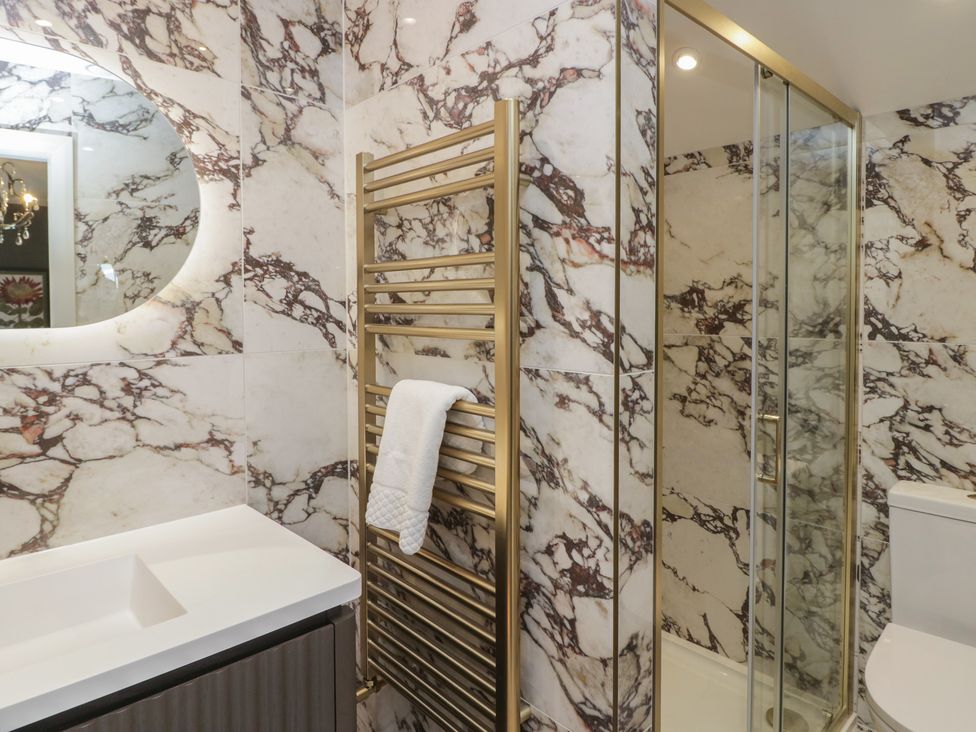 A bathroom with a sink, shower, towel radiator and toilet at The Boundary in Windermere