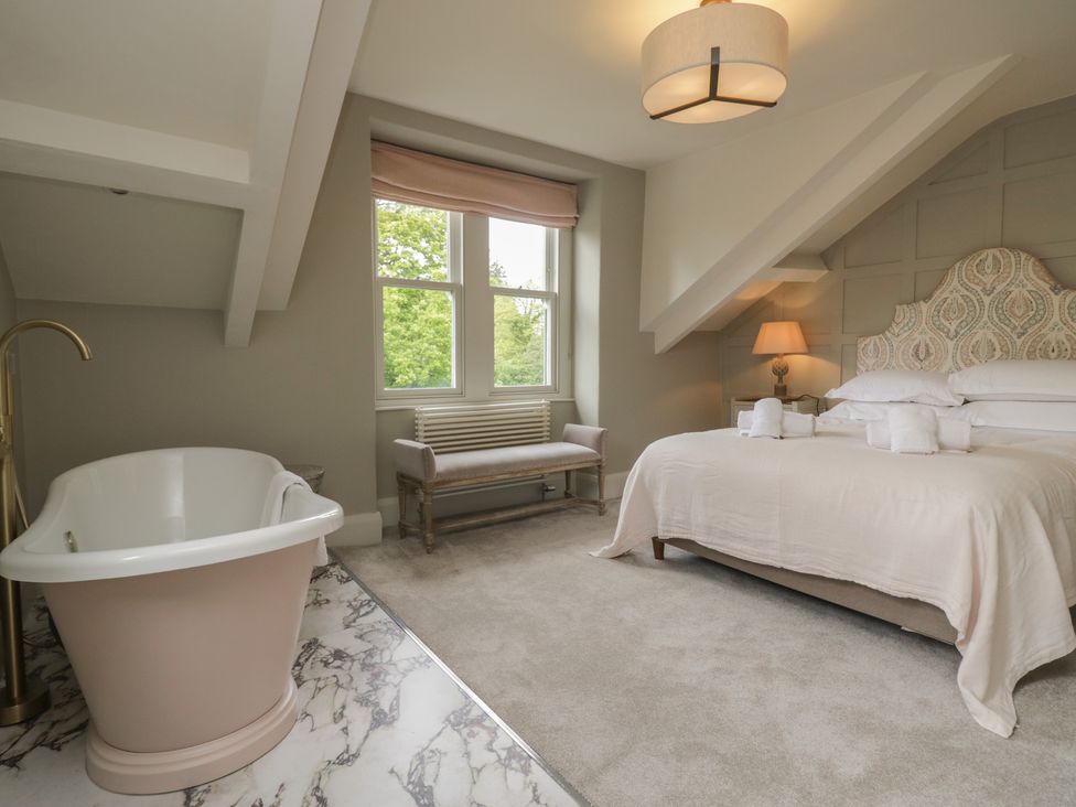 A bedroom with a bathtub and a bed at The Boundary in Windermere