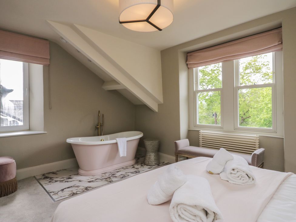 A bathroom with a bathtub and window at The Boundary in Windermere