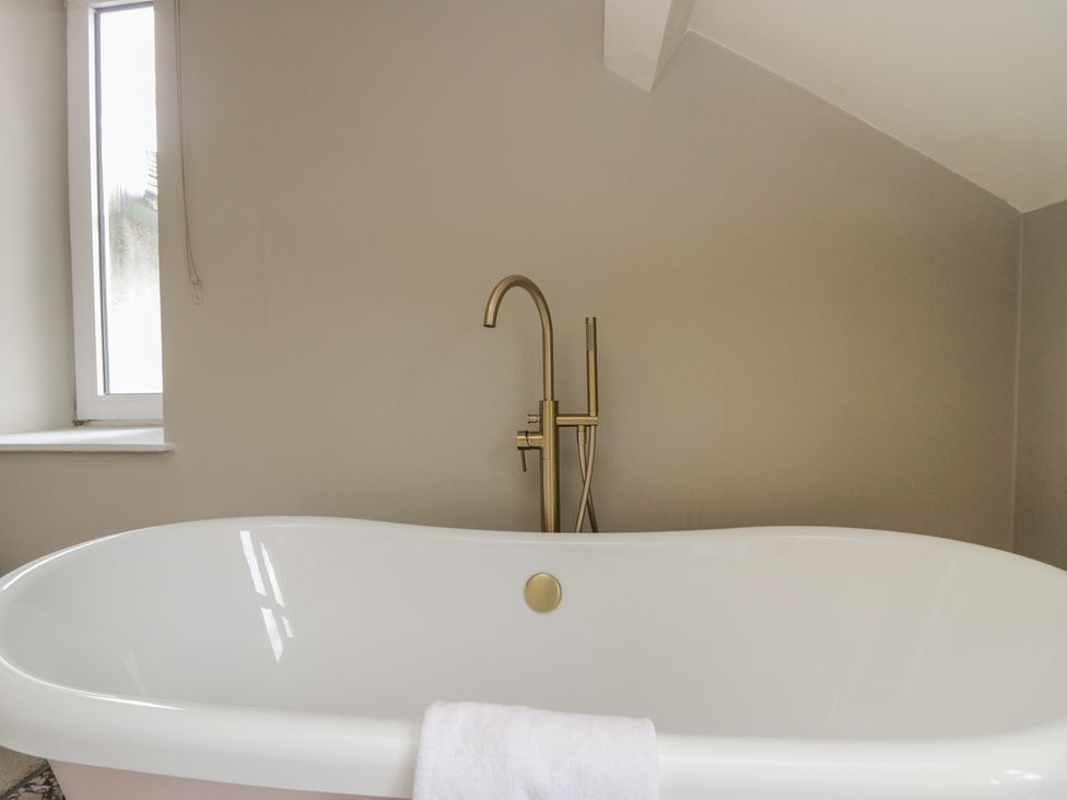A bathtub with a faucet and a towel at The Boundary in Windermere