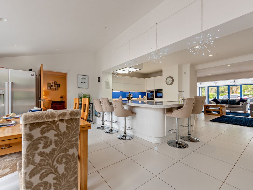 A kitchen with a dining area and bar stools at Sea Haze in Tenby