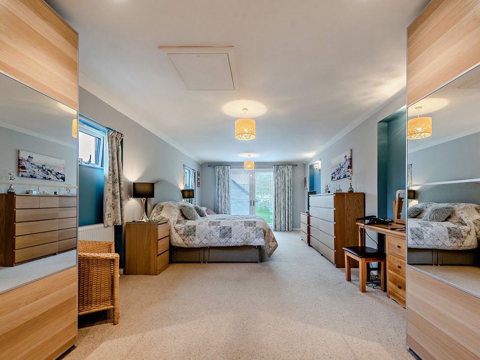 A bedroom with a bed and furniture at Sea Haze in Tenby