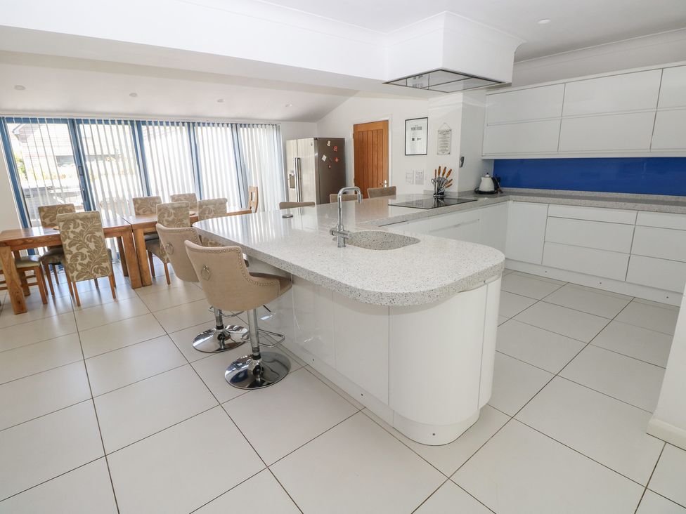 A kitchen with a dining table and chairs at Sea Haze in Tenby