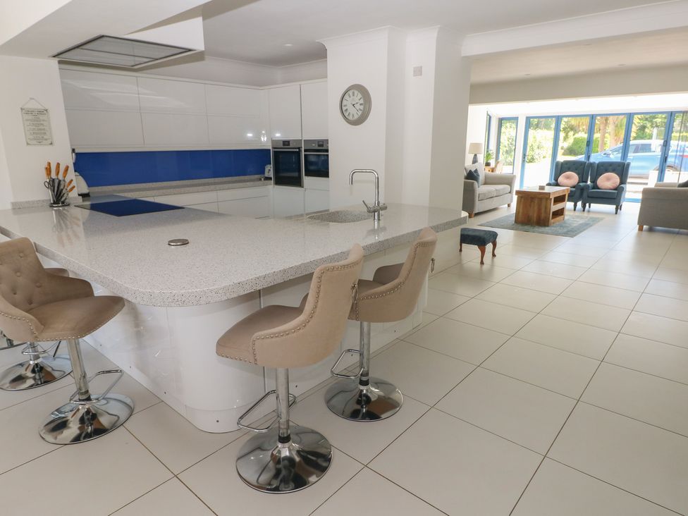 A kitchen with an island and stools at Sea Haze in Tenby