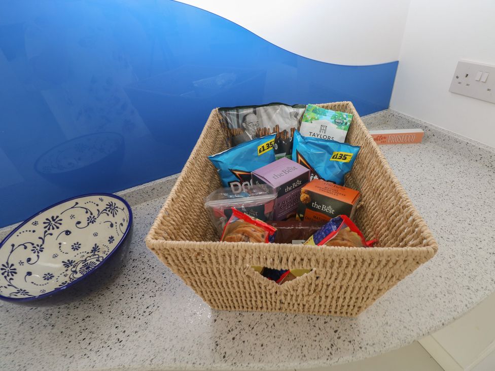 A basket with snack items on a countertop at Sea Haze in Tenby