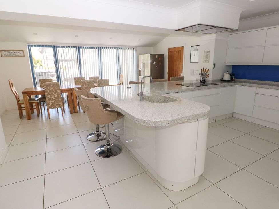 A kitchen with island and dining area at Sea Haze in Tenby