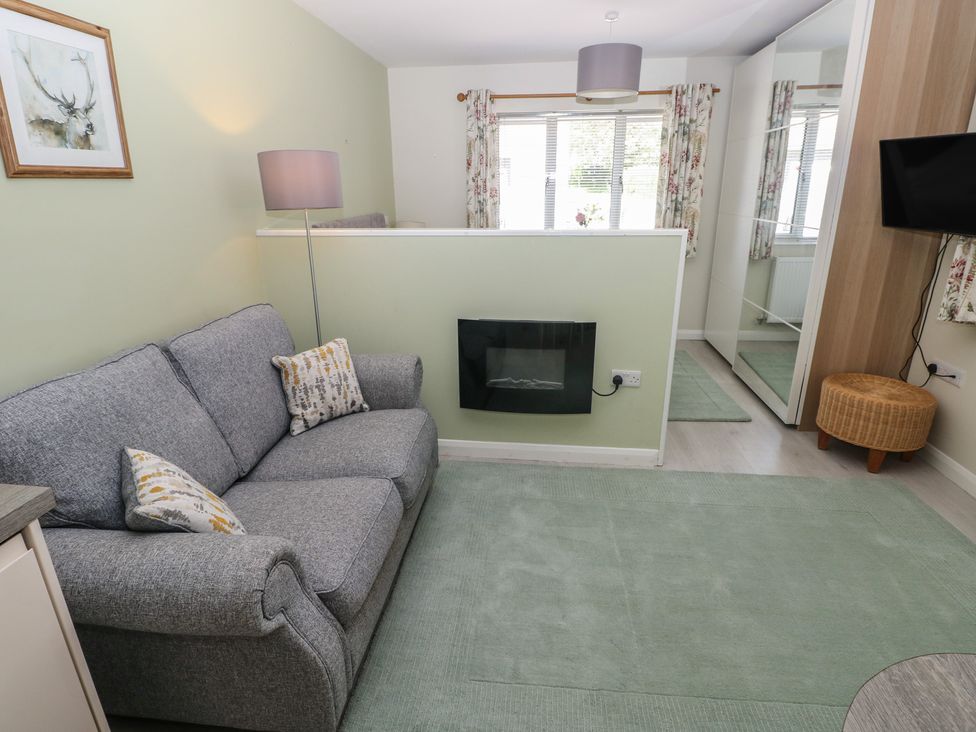 A living room with a sofa and a fireplace at Sea Haze in Tenby